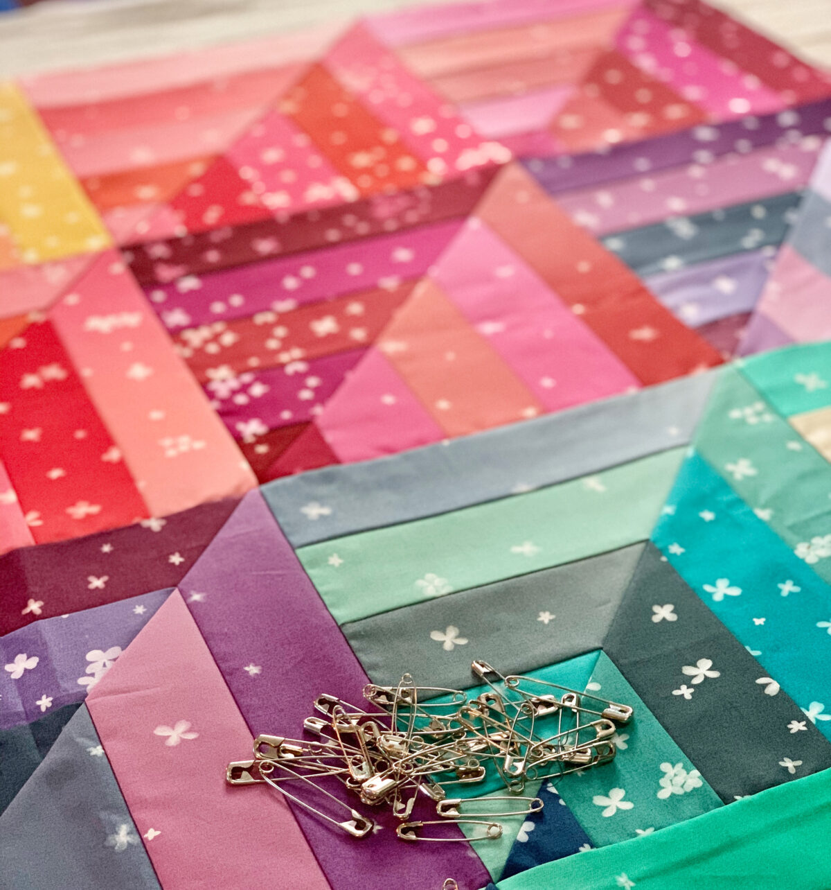 Pin basting on lucky log cabins quilt to in Ombre Blooms by V&Co