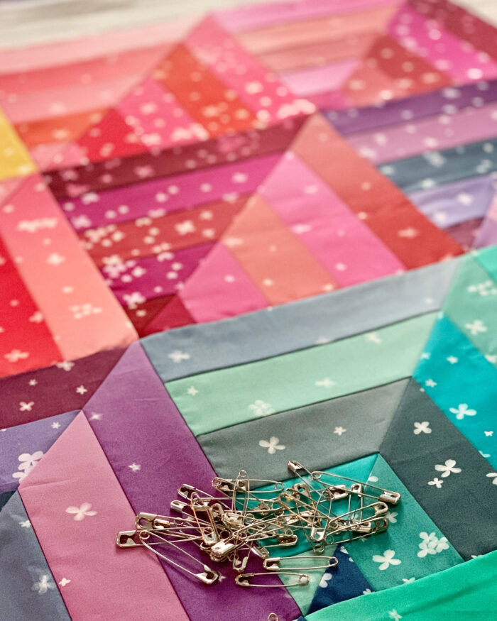 Pin basting on lucky log cabins quilt to in Ombre Blooms by V&Co