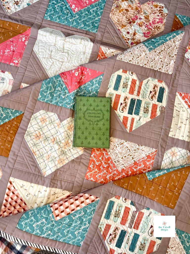 A literary themed quilt laid out with a book, emphasizing the cozy reading-room aesthetic.