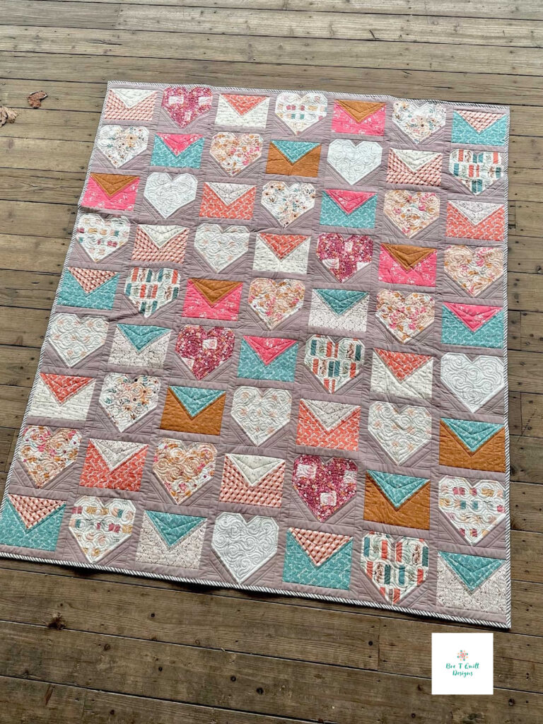 A completed literary themed quilt featuring heart and envelope blocks from the Love Letters pattern using Sharon Holland’s Bookish fabric.