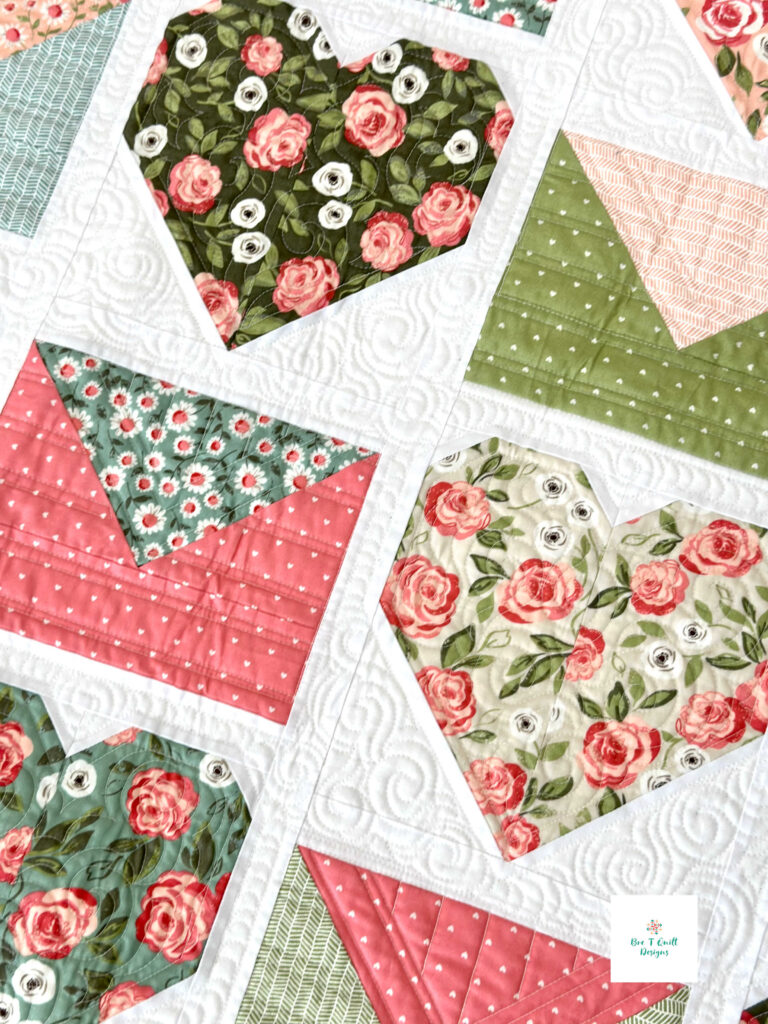 Close-up of a floral fabric heart tucked inside a pieced envelope block from the Love Letters Valentine quilt pattern.