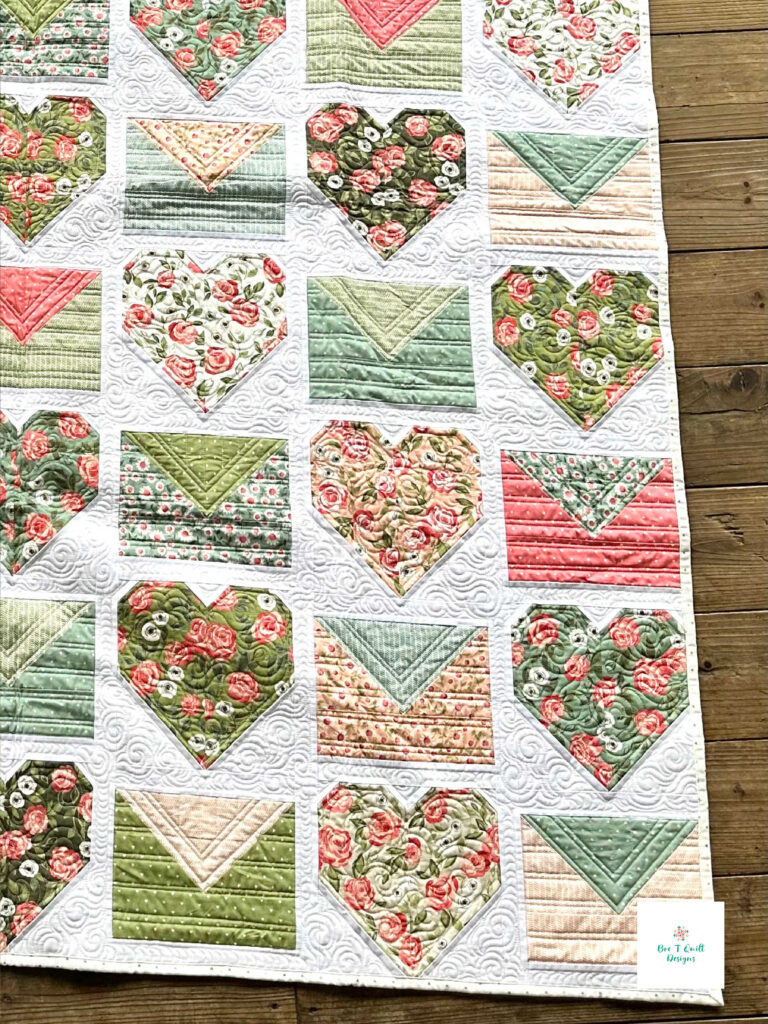 Custom quilting by Kelly Borns on the Love Letters Valentine quilt pattern, highlighting the intricate texture on the heart and envelope blocks.