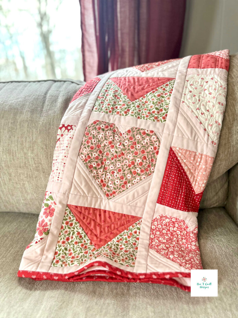 Love Letters Valentine’s Day heart quilt pattern draped over a couch with cozy minky backing