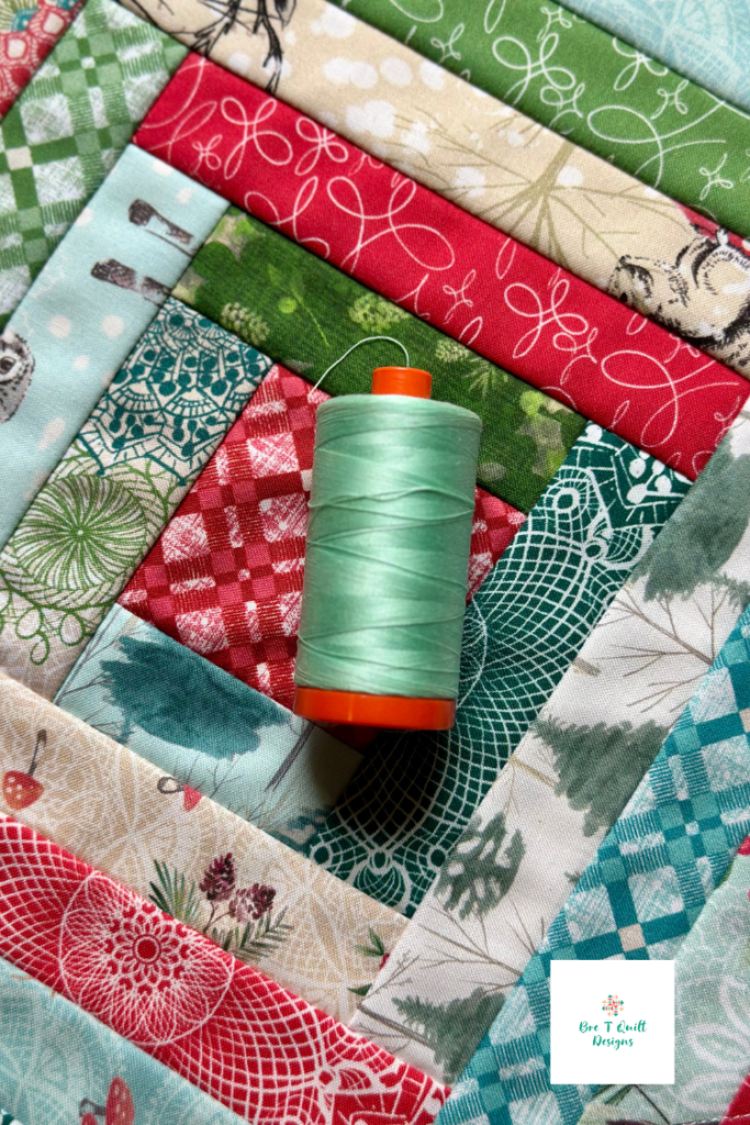 Close-up of a spool of light blue Aurifil thread resting on a diamond quilt-as-you-go hot pad made with Winter Haven fabric by Benartex