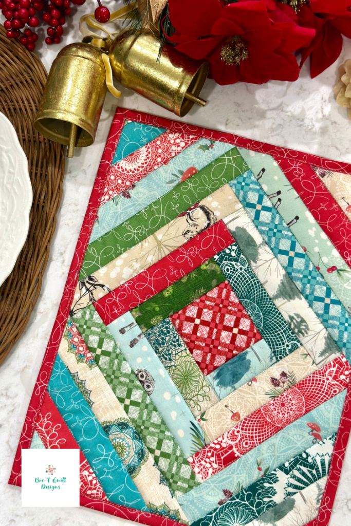 Overhead view of a diamond quilt-as-you-go hot pad in Winter Haven Christmas fabric on a holiday table with candles, plates, and florals