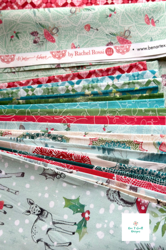 Strips and pieces of Winter Haven fabric by Rachel Rossi for Benartex showing Christmas prints in red, green, and winter tones