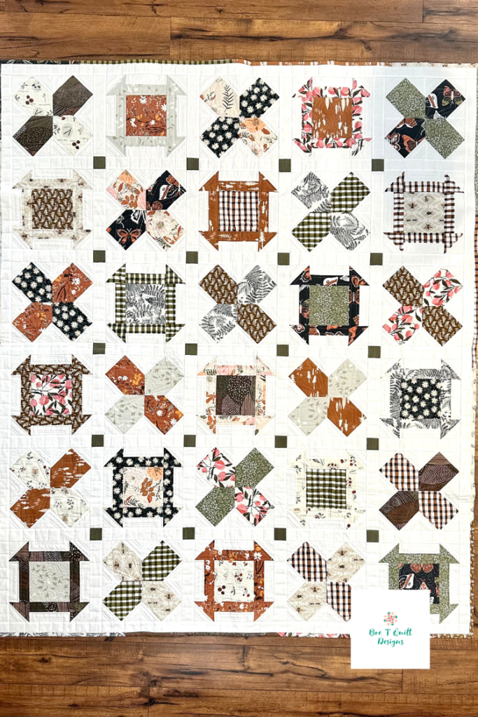 full view of bare roots quilt featuring mayflower quilt blocks and churn dash quilt blocks in green and brown fabrics. 