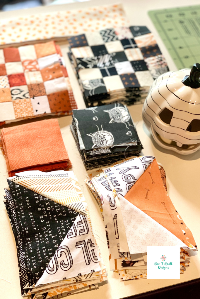 Close up of scrap pieces of fabric, pieced to make 16 patch blocks and flying geese.