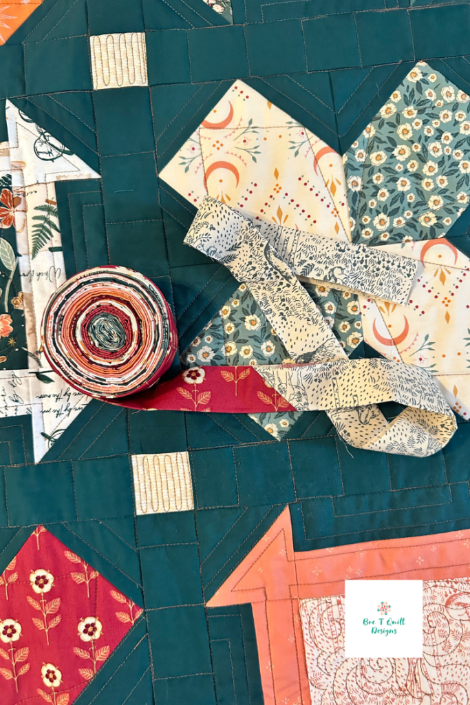 scrappy binding ready to be sewn onto teal bare roots quilt. 