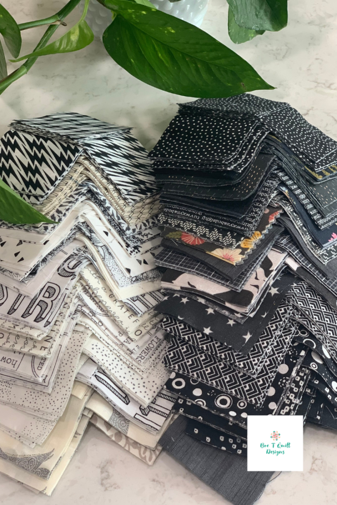 pile of black and white scrap pieces cut and ready to sew. 