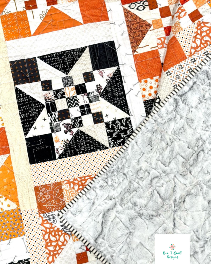 Close up of halloween quilt to show quilting, minky backing, and star block.