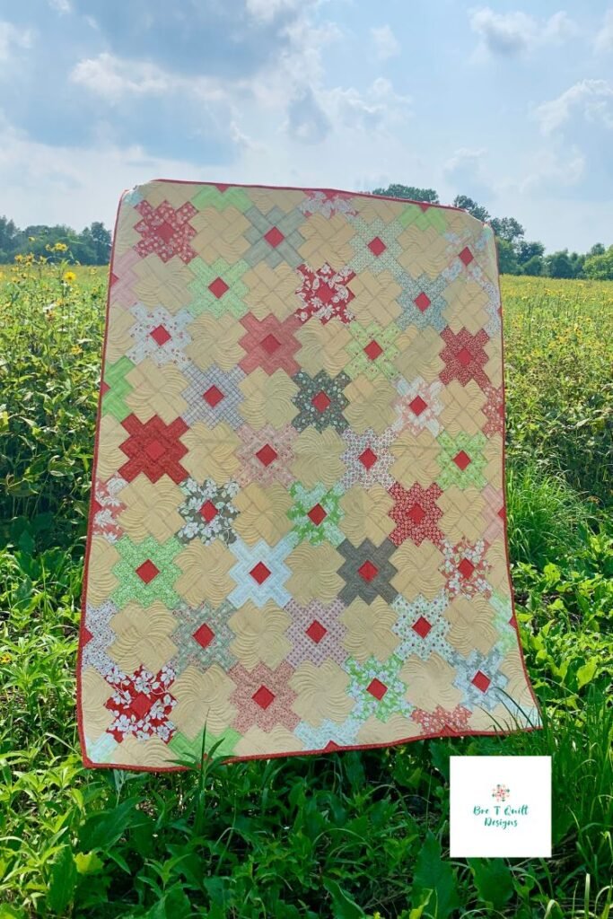 finished clover fields quilt top in yellow and pinks, a simple jelly roll quilt pattern. 